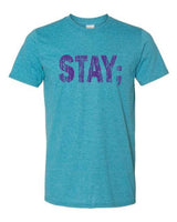 A teal tee with purple words that say Stay ;